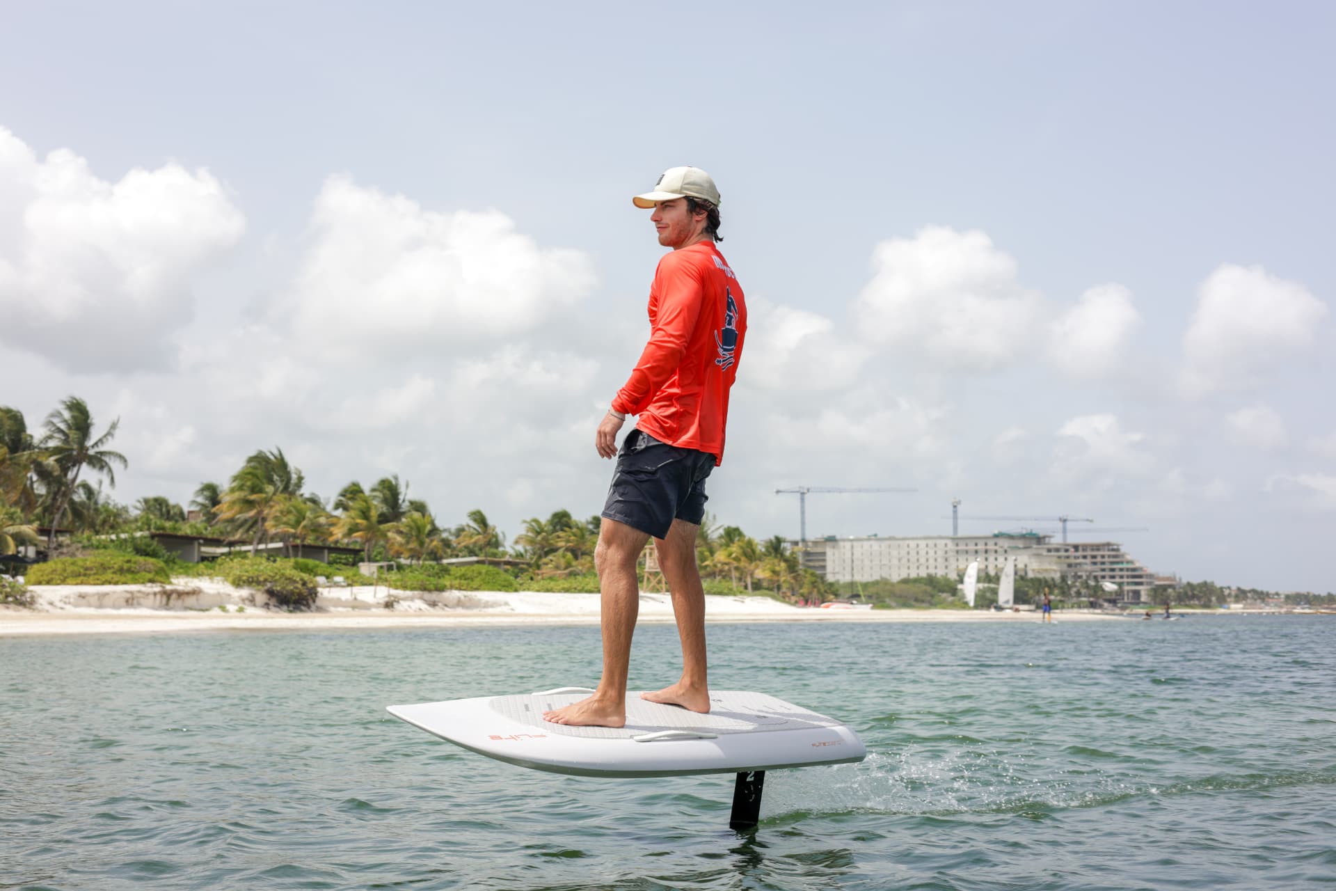 Caribbean Efoil rider standing in flight above turquoise Caribbean water